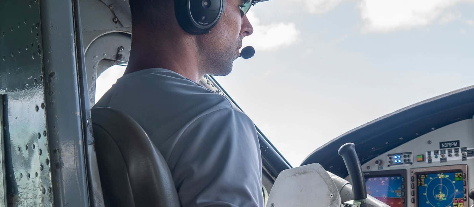 A pilot at the controls with the instrument panel lit